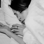 A serene capture of a woman peacefully sleeping under a cozy blanket.